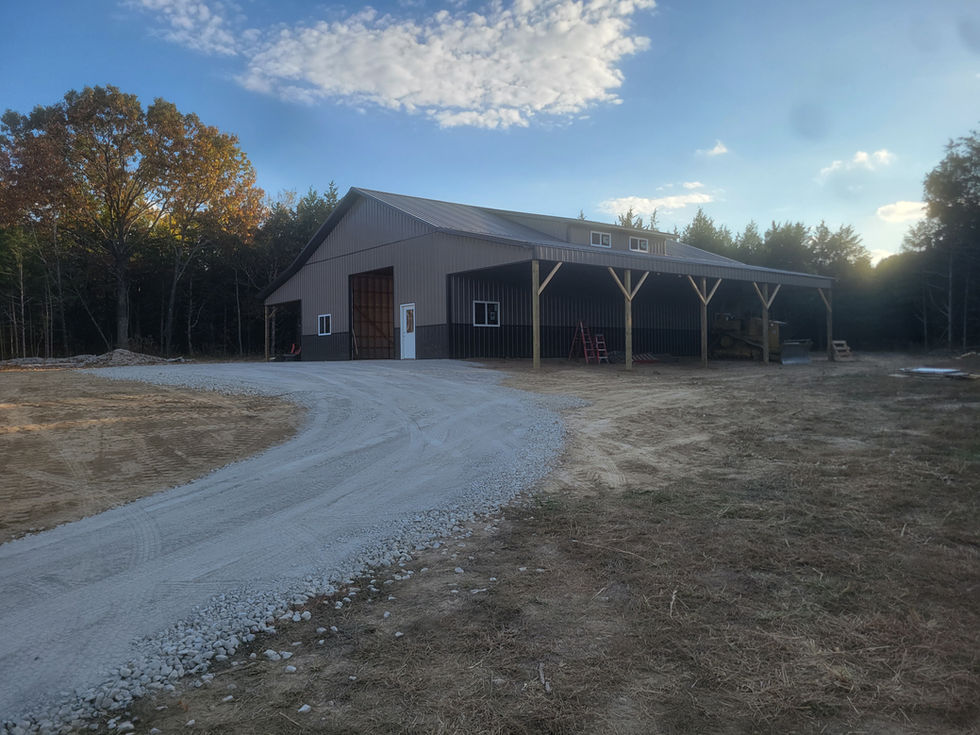 Large barn with open shelter and driveway.