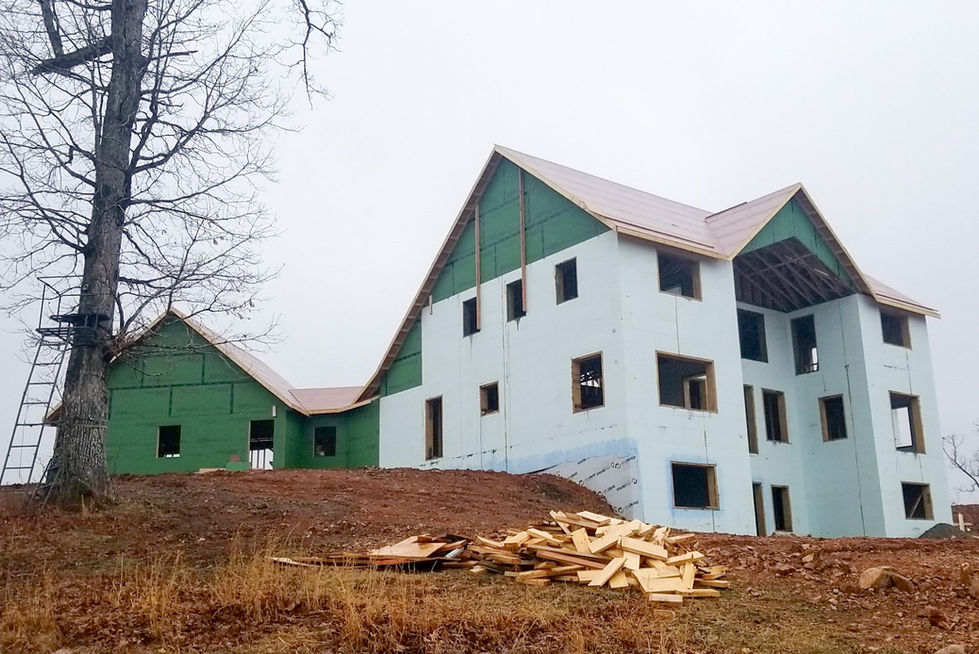 House under construction with green and white exterior.