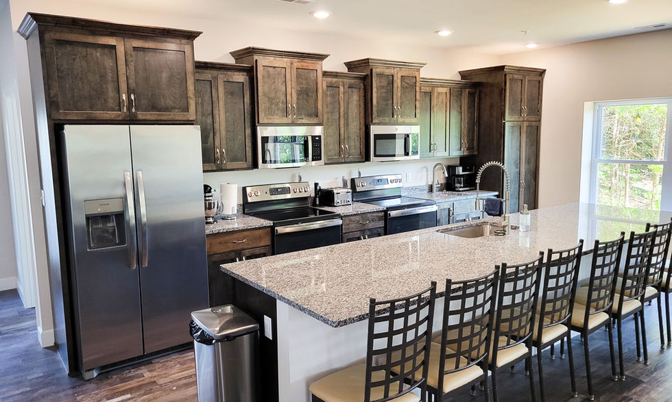 Modern kitchen with granite island and wooden cabinets.