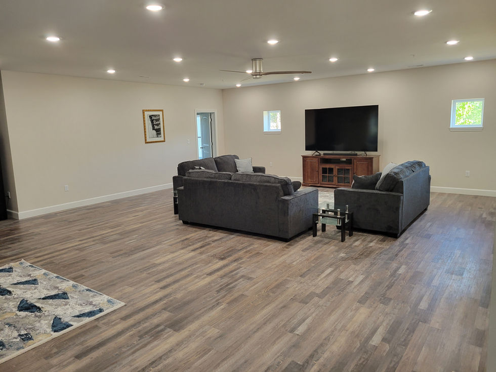 Spacious living room with sofas and large TV.