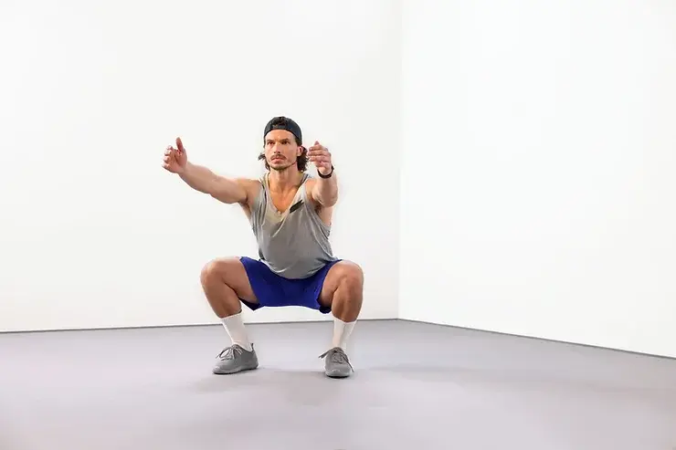 Personal trainer demonstrating proper squat form for functional fitness in Edmonton