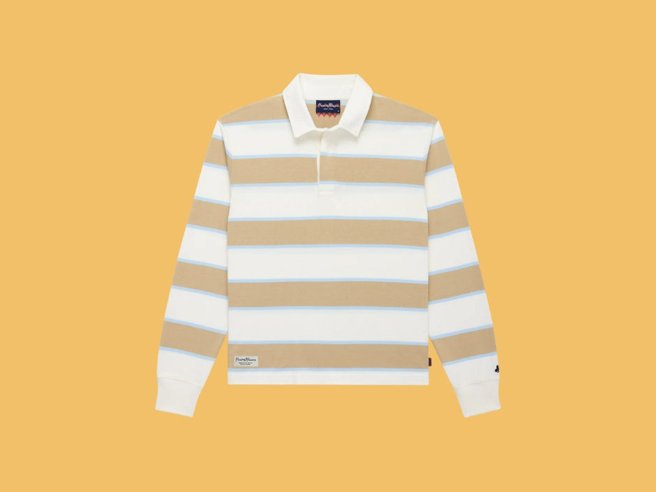 Striped rugby shirt with beige and white horizontal bands on an orange background. Features a collar and tag with "Rowing Blazers".
