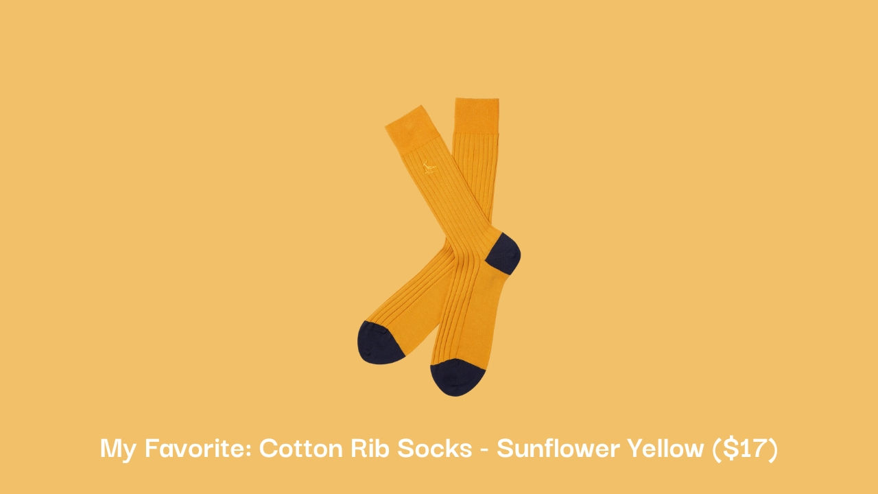 Charles Tyrwhitt sunflower yellow cotton rib socks in front of beige background.