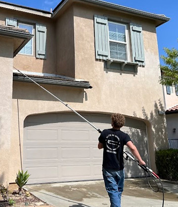 Washing the second-story stucco walls and windows of a large residential home in the SCV.