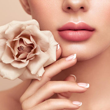 woman with full lips holding rose by her chin