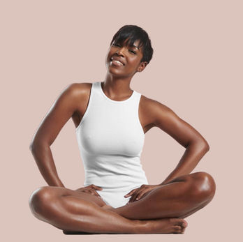 fit happy black woman sits in lotus pose smiling