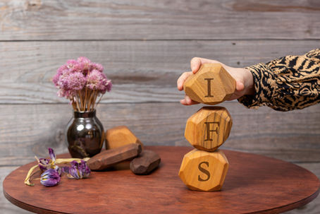 Letters IFS written on wooden irregular blocks. Internal Family Systems psychotherapy treatment concept. internal family systems. inner child work. parts work.