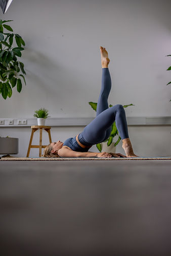 Frau macht Pilates Übung am Boden, Leichtigkeit und Kraft.