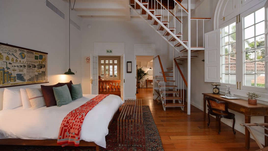 Suite spacieuse avec escalier intérieur et décoration élégante à la Villa Barranco, boutique hôtel de luxe dans le quartier de Barranco, Lima, Pérou.