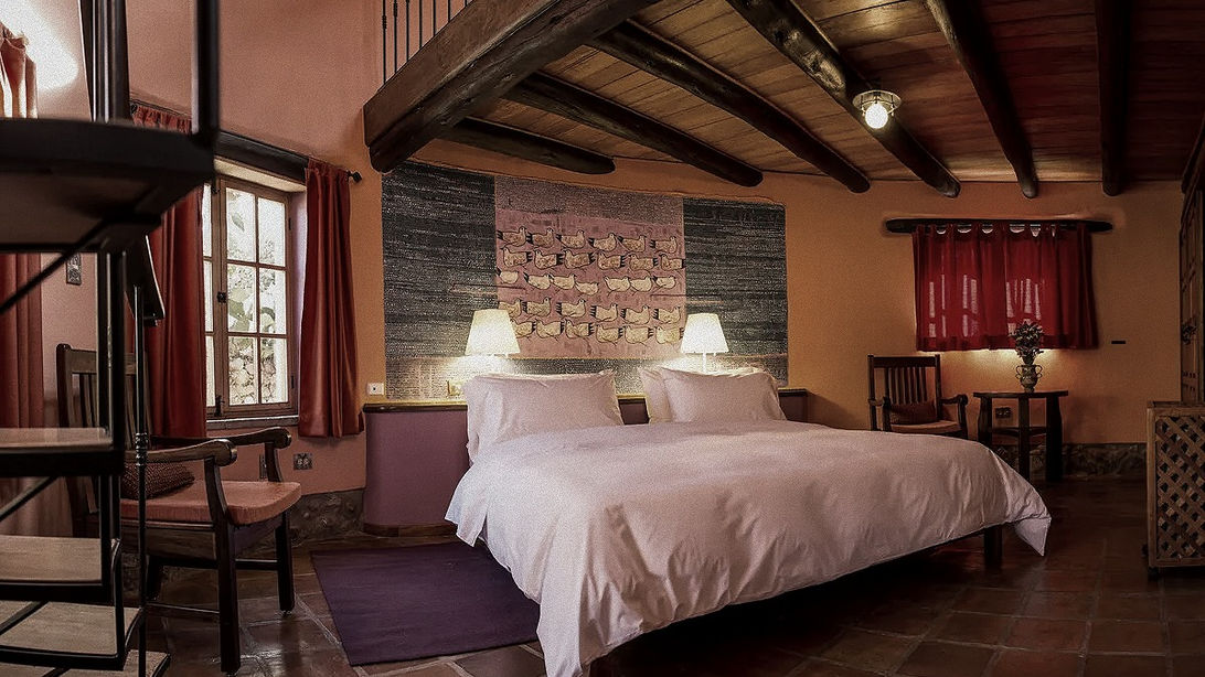 Chambre parentale de la Superior Family Casita avec mobilier en bois massif et escalier vers la mezzanine au Sol y Luna