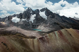 Paysage de la montagne Vinicunca avec strates colorées et sommets enneigés des Andes, Graine de Voyageur, agence de voyage au Pérou, luxe.