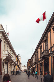 Photo d’une rue pittoresque du centre historique de Lima, bordée de bâtiments coloniaux aux façades colorées et de balcons en bois sculptés. L’image reflète l’ambiance vibrante et authentique de cette zone emblématique du Pérou.