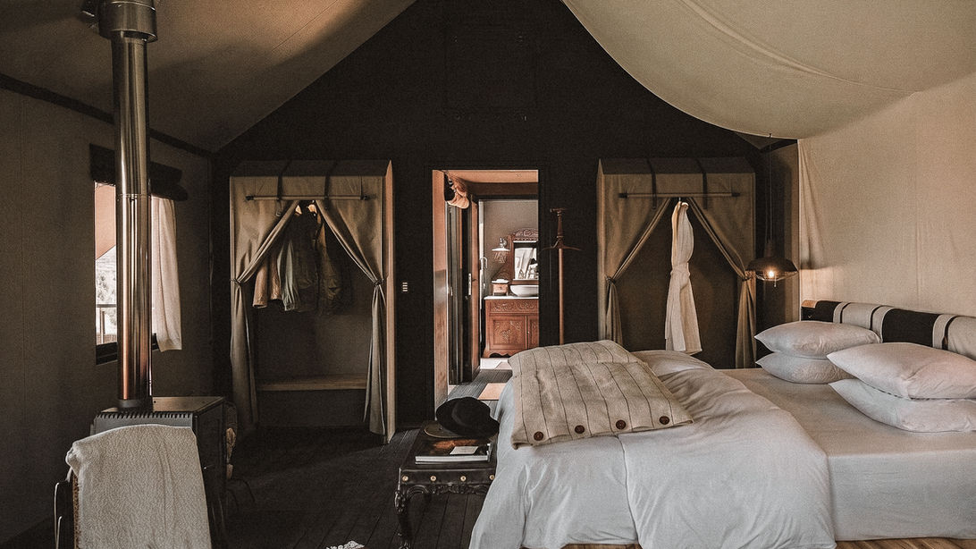 Chambre de prestige sous la tente de canevas du Puqio dans le Canyon de Colca : lit King Size en bois brut et poêle à bois d'altitude, expérience Graine de Voyageur.