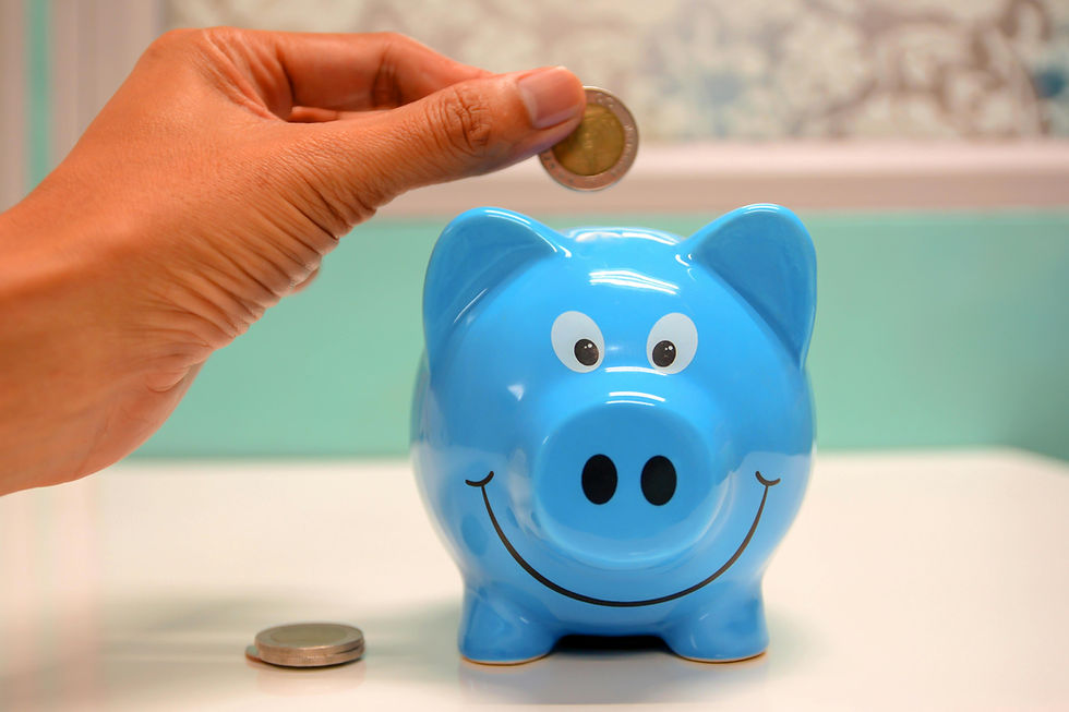 Blue Piggy bank with hand putting a one euro coin into it as part of a travel fund