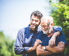 A man and his older adult father hug to represent emotional well-being achieved with Caregiving Compass