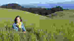Our founder in a field with ocean view