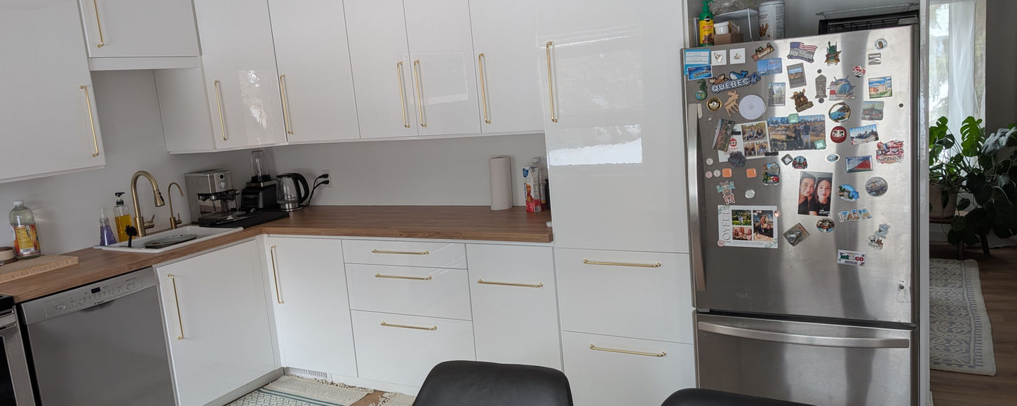 Modern kitchen with white cabinets and wood countertop installed in Regina by B-Flex Services.