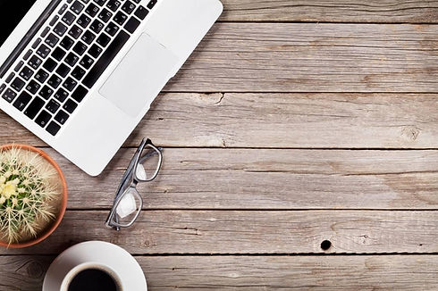 62201490-desk-table-with-laptop-coffee-and-glasses-on-wooden-table-workplace-top-view-with