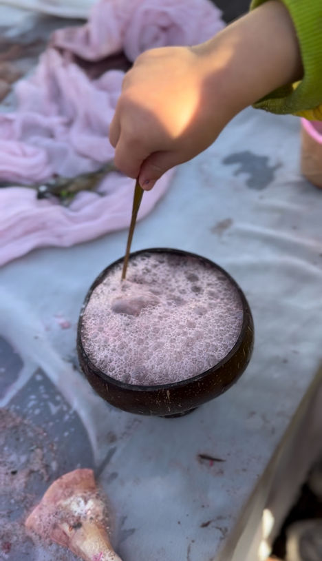Child pouring fizzy potion into bowl during hands-on messy play activity