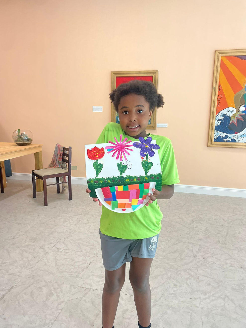 Child showing completed art at art class