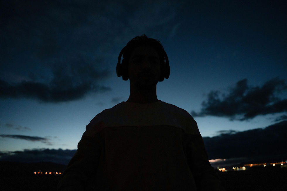Embracing the quiet between notes, a solitary figure finds tranquility in the silence of music against a dusky sky.