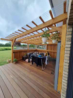 Komplette Ansicht der Terrasse mit einem Boden aus hochwertigem Bankirai sowie einer Holzüberdachung mit gemütlicher Sitzecke in Wacken.