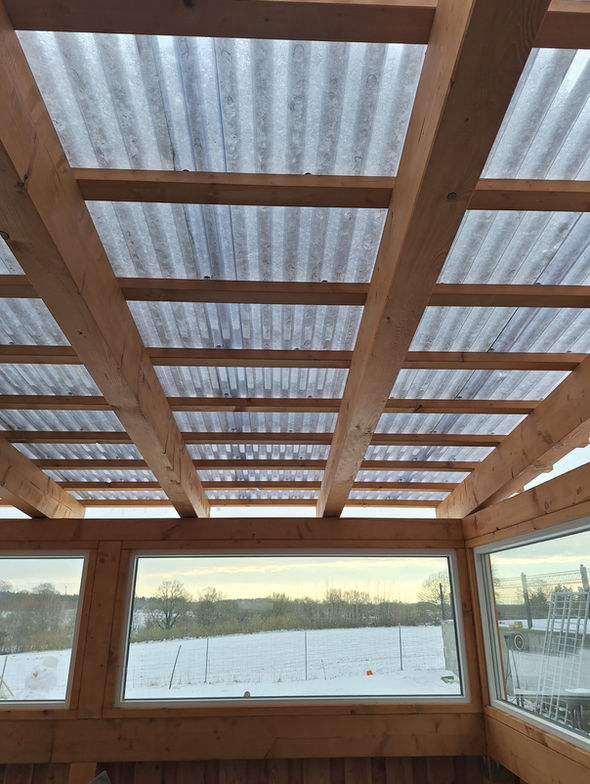 Terassenüberdachung aus Holz mit Fassade aus Lärchenbretter und Fensterelementen in Wacken