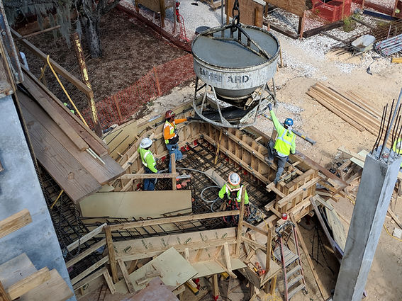 Construction workers pouring concrete into a foundation formwork