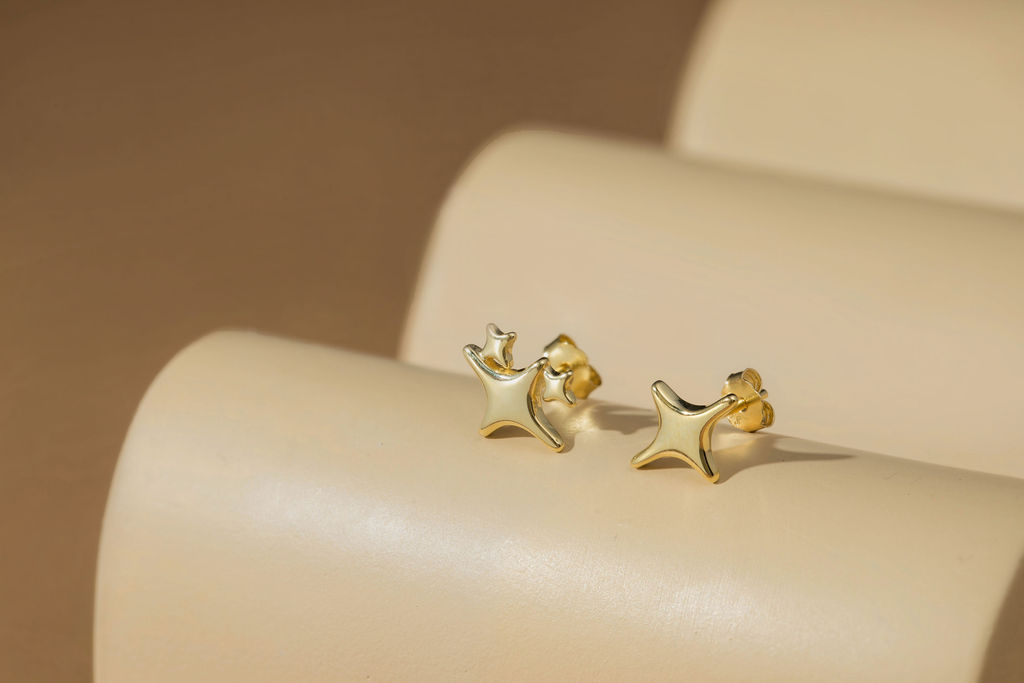 Asymmetric twilight star stud earrings on concrete tray
