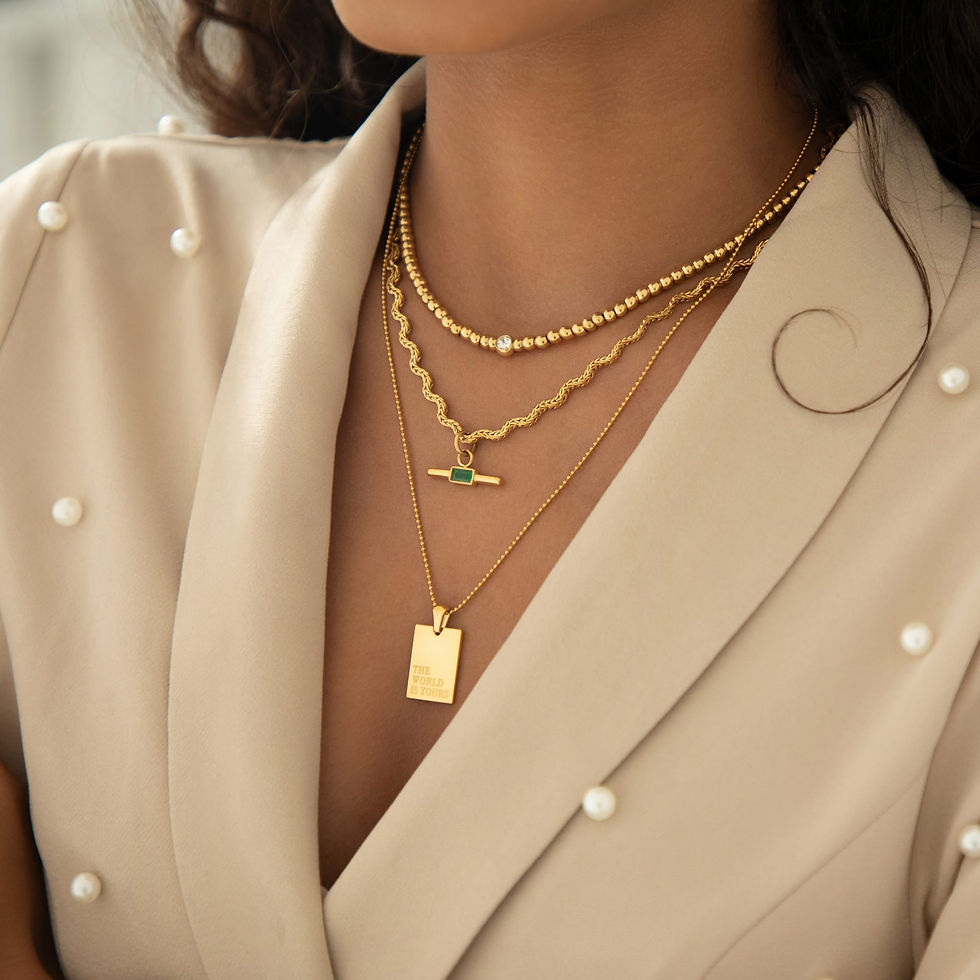 Close-up view of minimalist gold necklaces stacked on a model