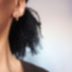 Model wearing small minimalist gold africa outline studs