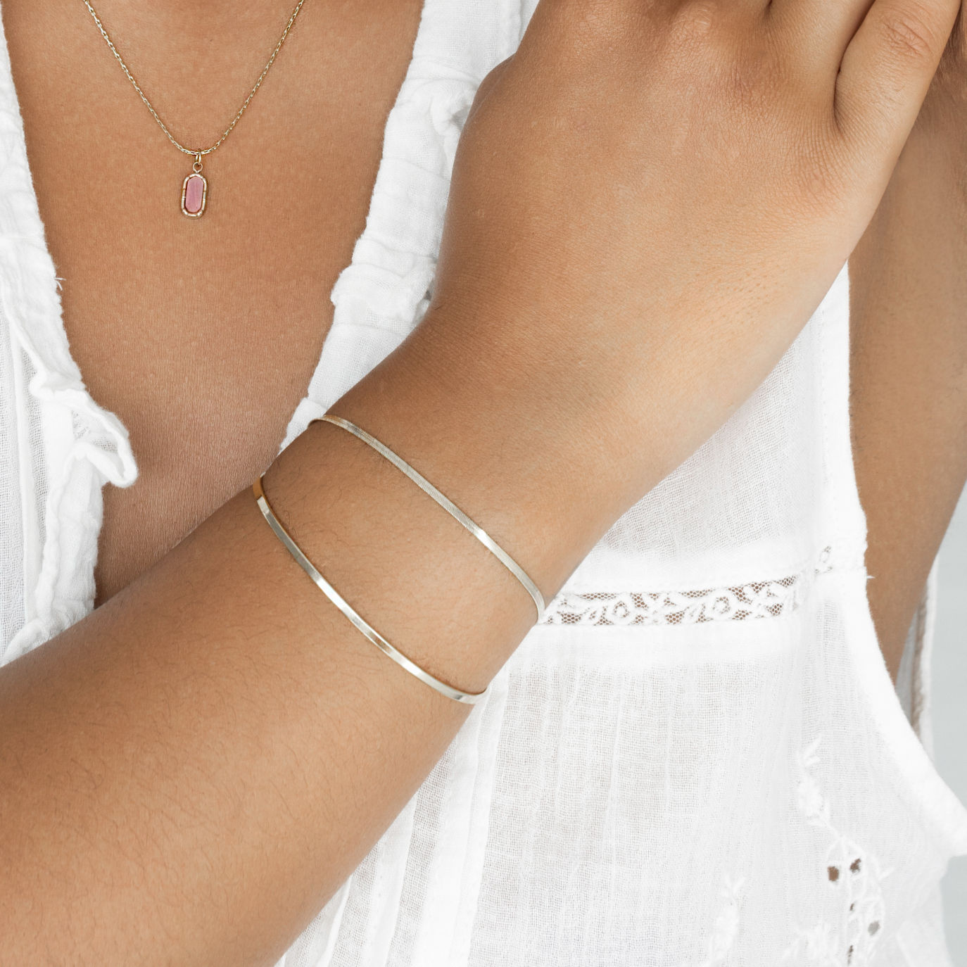 Woman wearing two silver bracelets including herringbone bracelet 2mm width.