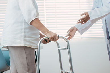 Physical therapist providing assistive device training and guiding a patient who is learning to use a walker