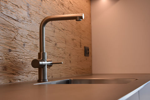 Wasserhahnen in einer Küche mit Holzoptik Rückwand