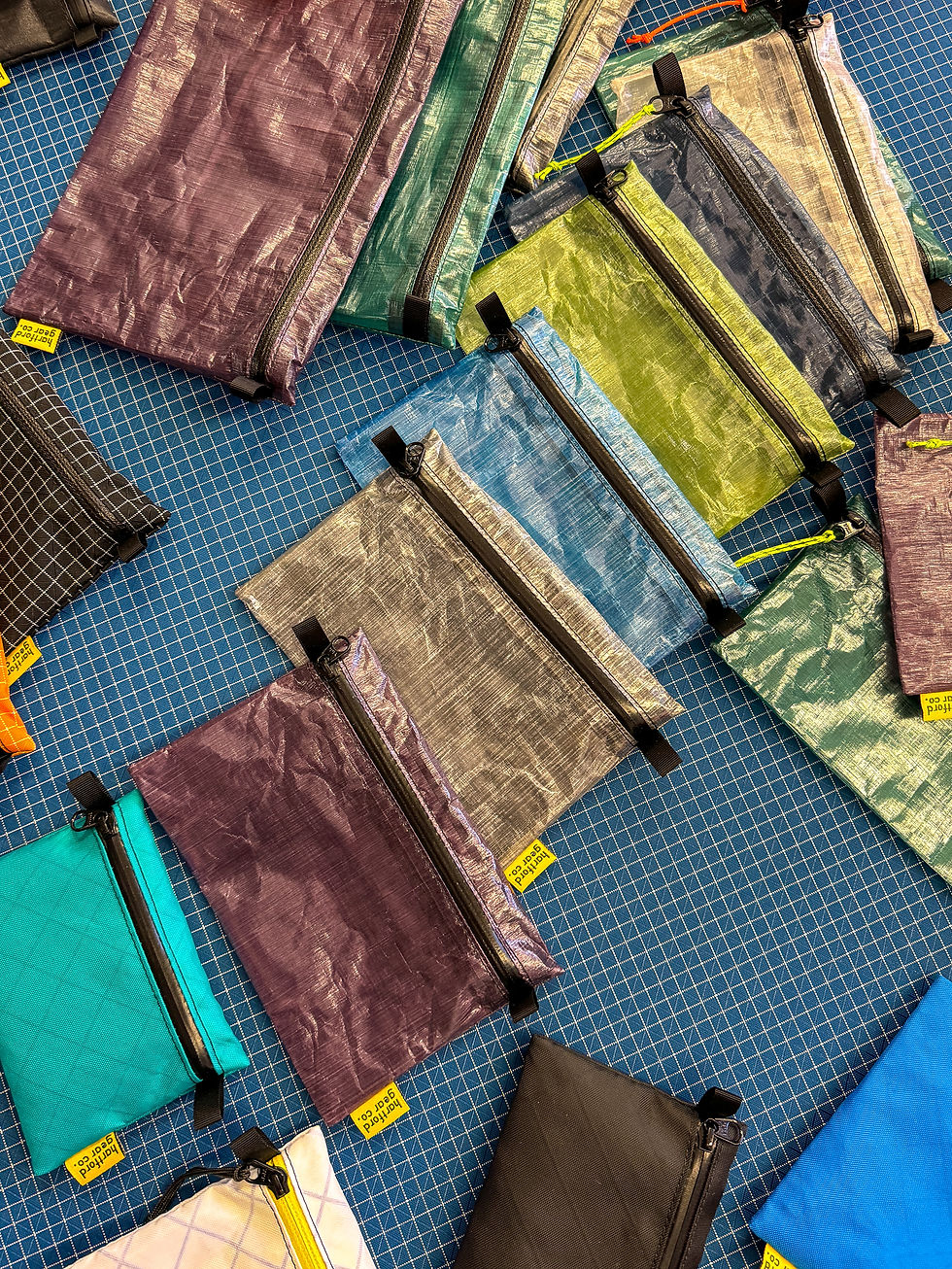 Various colorful zippered pouches laid out on a table for display 