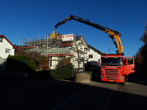 Der Lastwagenkran hebt die Solarmodule auf das Dach.