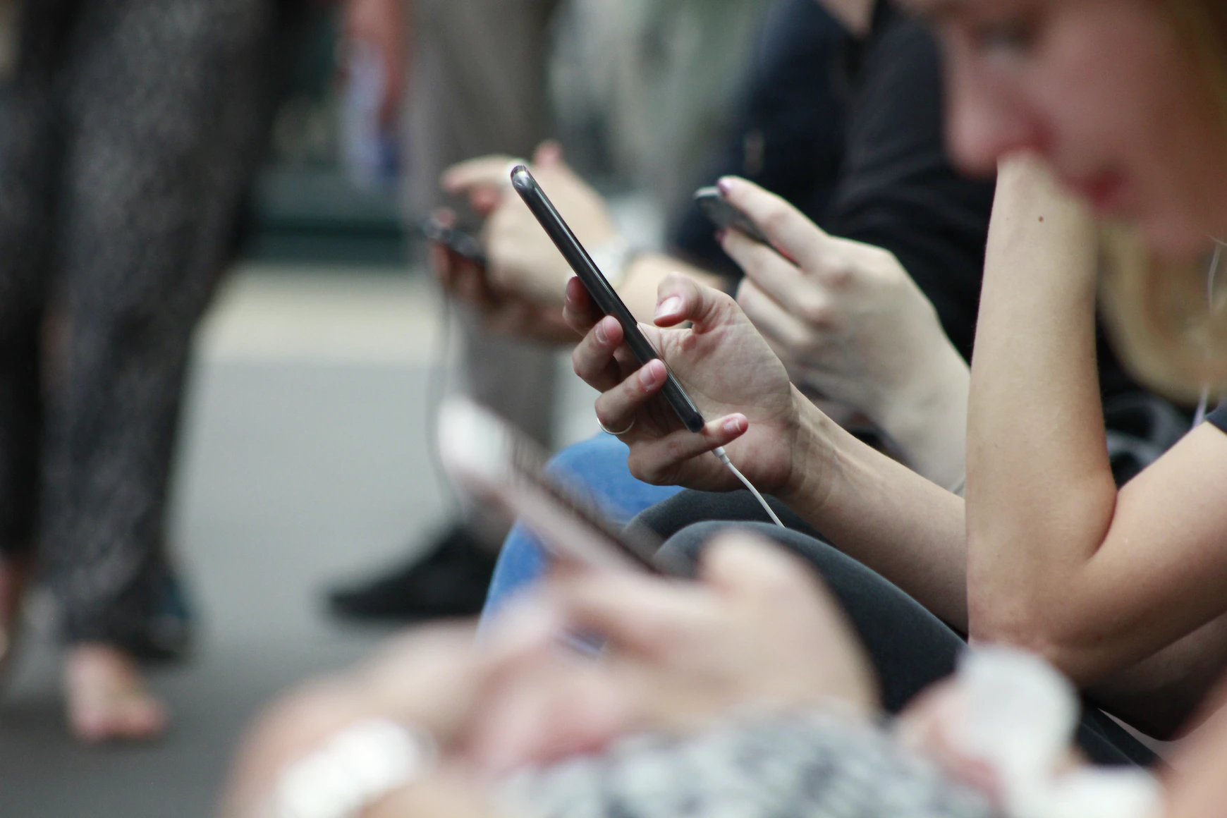Row of people using smart phones