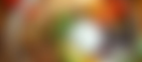 A top down image of a high protein taco bowl with meat, black beans, avocado, vegetables, rice and sour cream