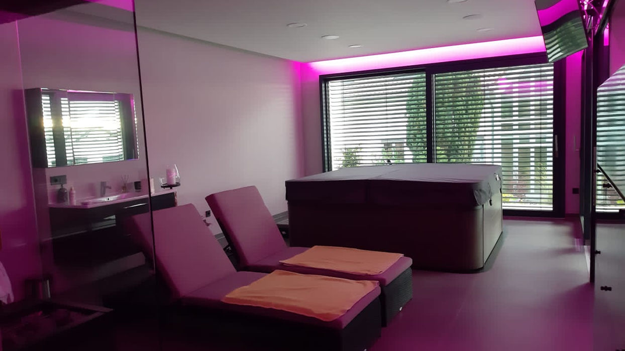 Moderner Wellnessbereich mit Whirlpool und Liegestühlen.