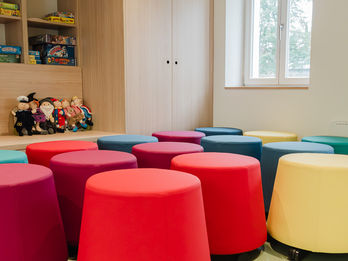 Sitzbereich mit bunten Hockern und Einbauschrank