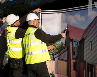 Boom Construction workers applying vinyl signage at Codicote