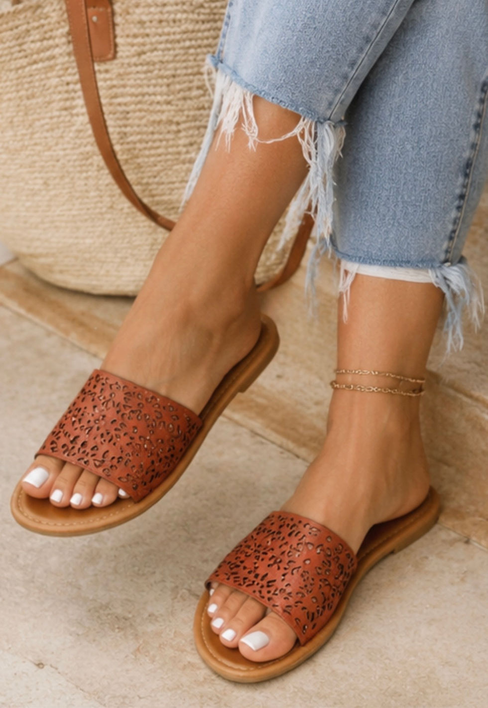 Women's tan cutout slide sandals with decorative perforated pattern and cushioned sole for everyday comfort.