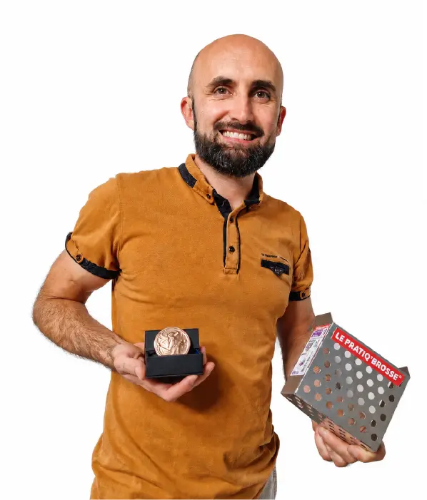 Laurent Capuano tenant le Pratiq’Brosse R130G 2-en-1 pour seau rond avec la médaille de bronze du concours Lépine 2026