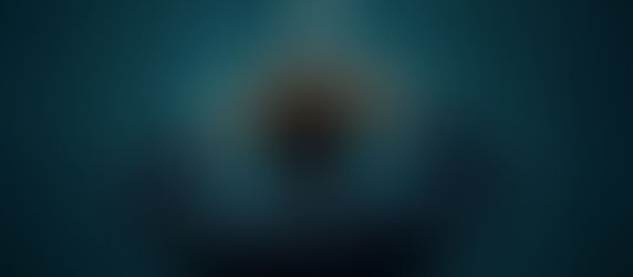 Brown haired person in a dark blue suit in front of a teal background, hands on head with a question mark above