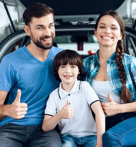 Happy family sitting in car trunk enjoying a road trip with cheap full coverage car insurance and auto insurance near me