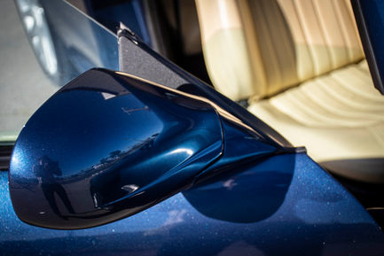 a close up of a blue car 's side mirror