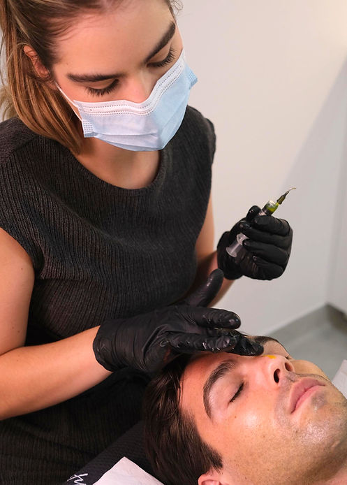 Aesthetician performing eyebrow treatment on client