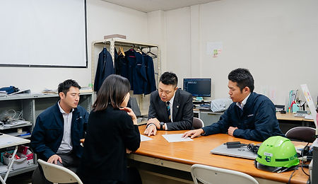 社長と社員3名が座りながら、話し合いをしている様子