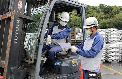 ヘルメットを被った男性社員2名が紙を見ながら話し合っている様子