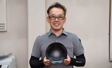 笑顔で製品を持つ開発部のＫさん